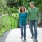 lifestyle image of two people walking through a park area
