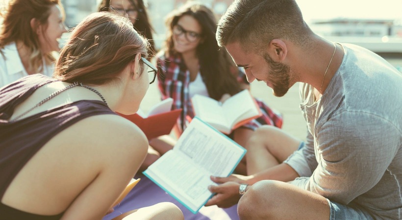 lifestyle image of a group of people reading together outside