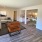 rendering of living and connected kitchen area on wood-style flooring